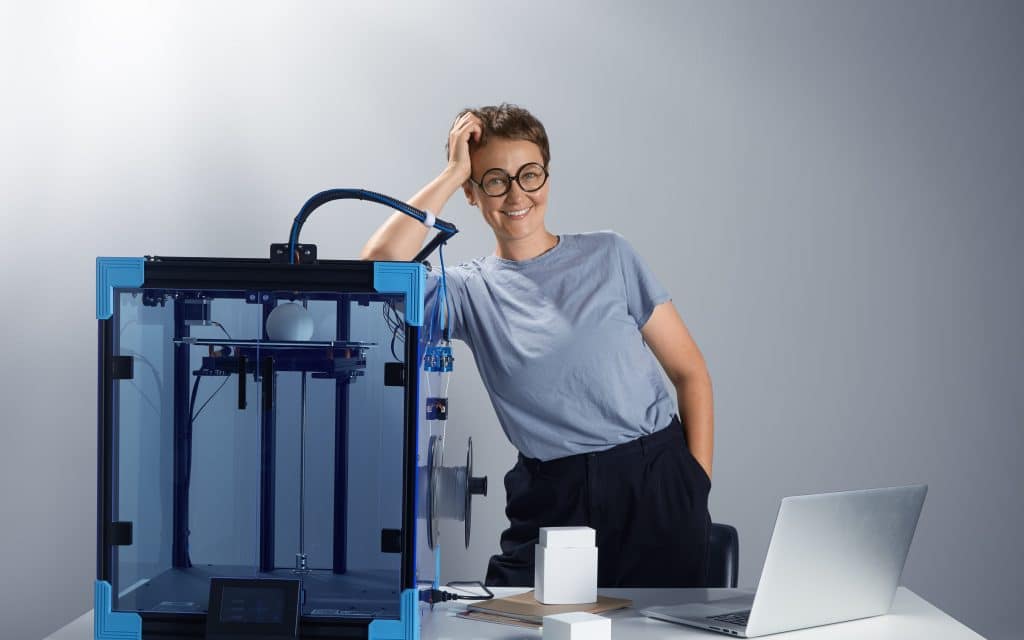 caucasian beautiful lady glasses smiling near 3d printing machine her office new technologies small businesses concept computer prototypes table tech ambient jpg photo edited howto3Dprint.net Discover The World of 3D Print