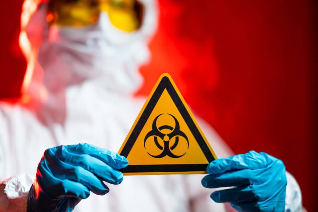 doctor holds biohazard sign frightening red background quarantine zone howto3Dprint.net Discover The World of 3D Print